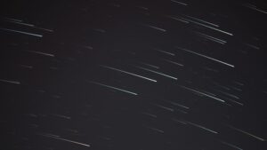 A mesmerizing long exposure photograph capturing streaking stars in the night sky.