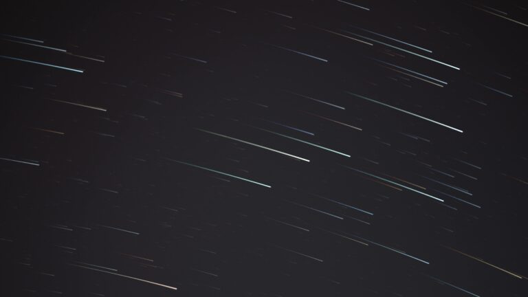 A mesmerizing long exposure photograph capturing streaking stars in the night sky.