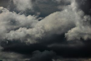 Moody and dramatic overcast cumulus clouds fill the sky, creating a captivating dark sky scene.