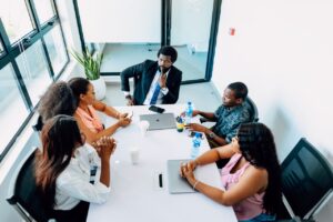A group of professionals engaged in a business discussion around a table in a Lagos office.